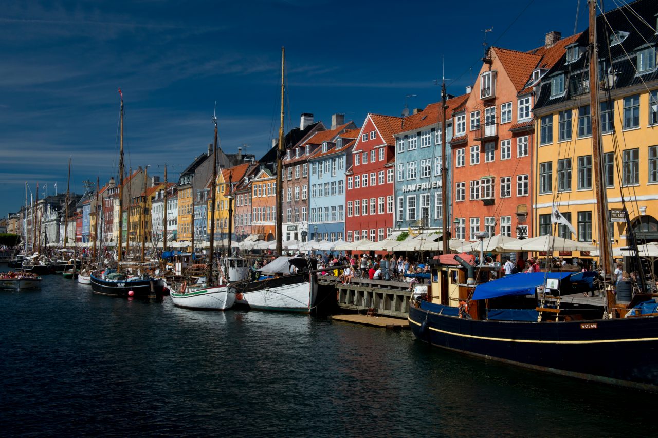 An evening view of buildings of Nyhavn in Copenhagen by the shore