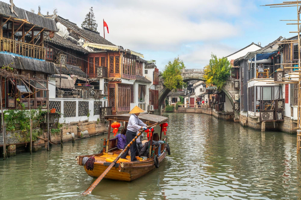 a-boat-carrying-visitors-travelling-through-zhujiajao-water-town