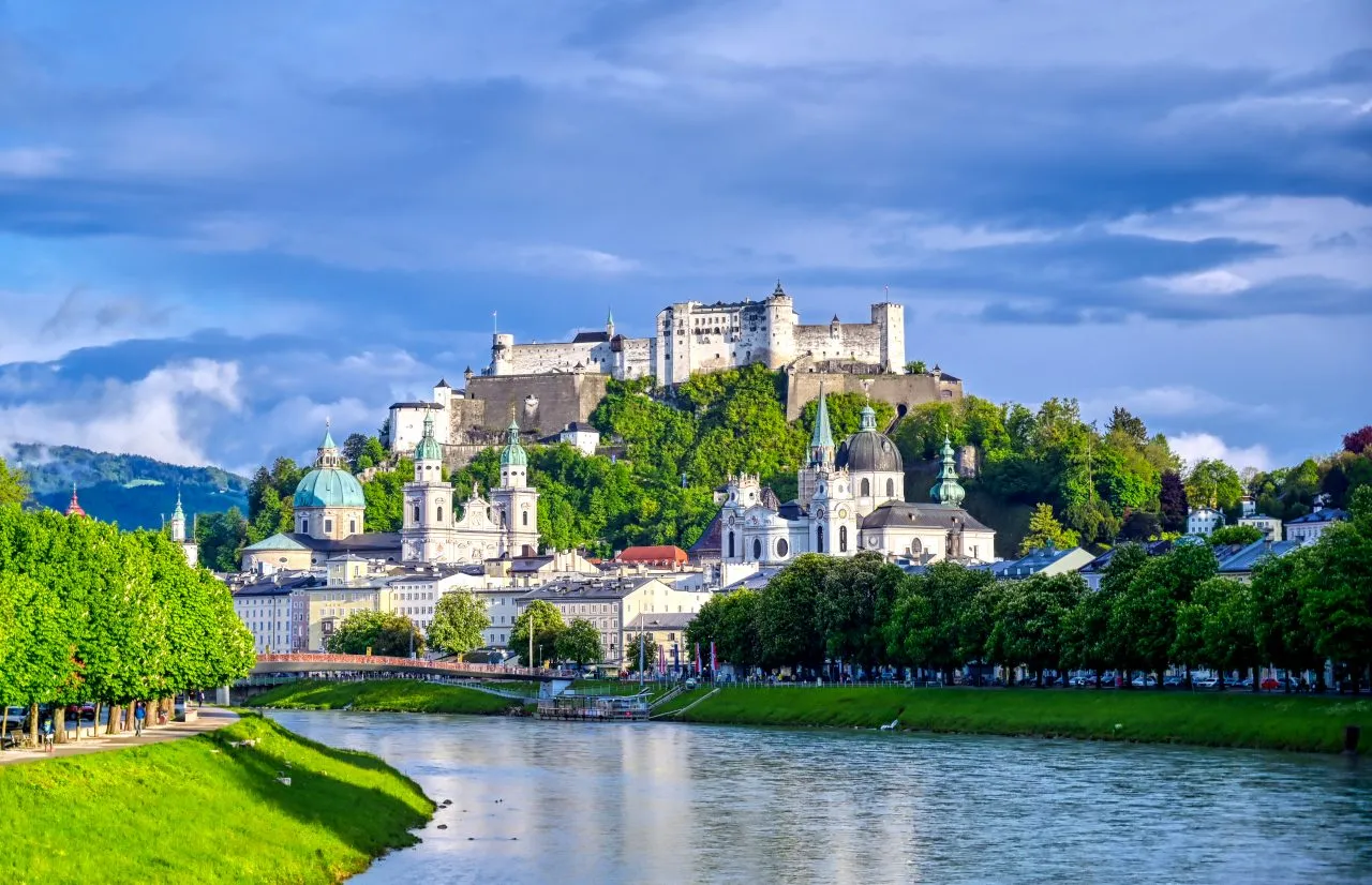 European town with a hilltop fortress and river running through the city