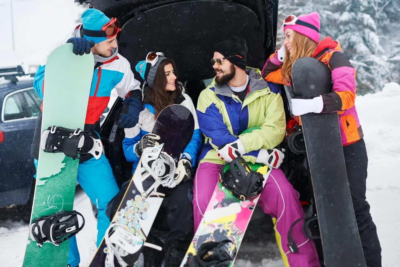 Group of snowboarders in colorful gear standing together in the snow