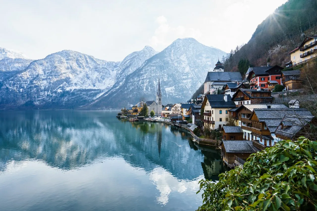 Snow-covered alpine village on Lake Hallstatt in Upper Austria, with mountains and lakeside houses