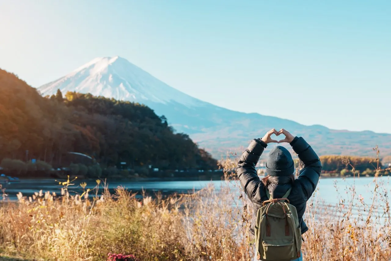 Traveler admiring Mount Fuji beside Lake Kawaguchi in Fuji Five Lakes
