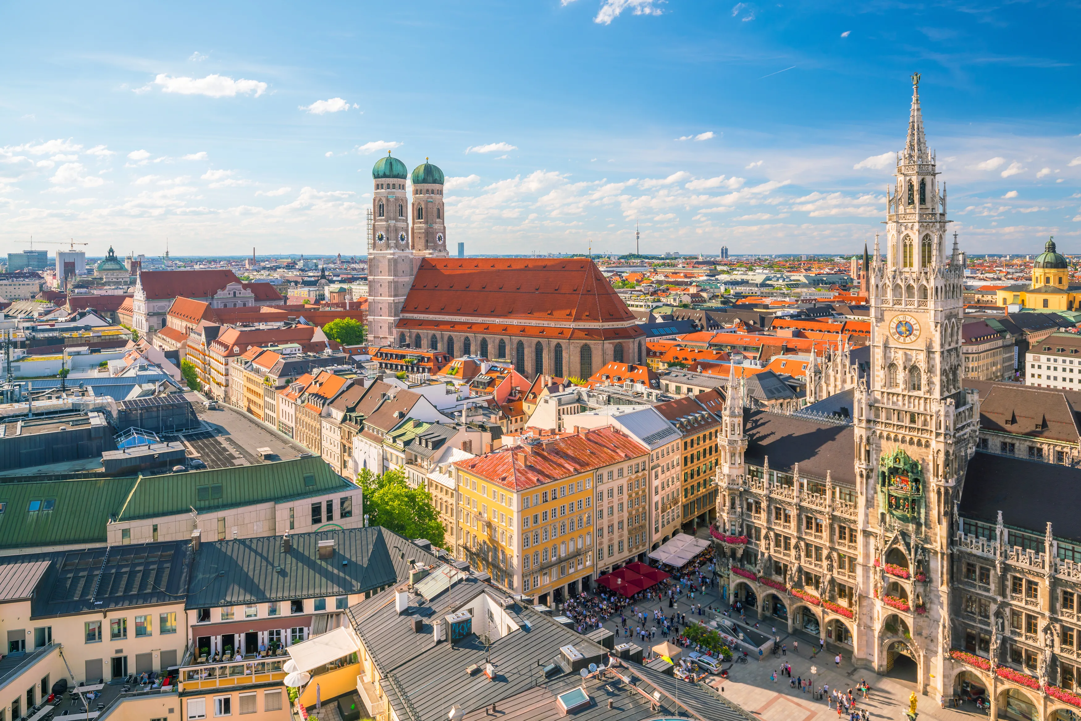 A high-angle, wide-angle panoramic shot overlooking Marienplatz and the cityscape of Munich, Germany.