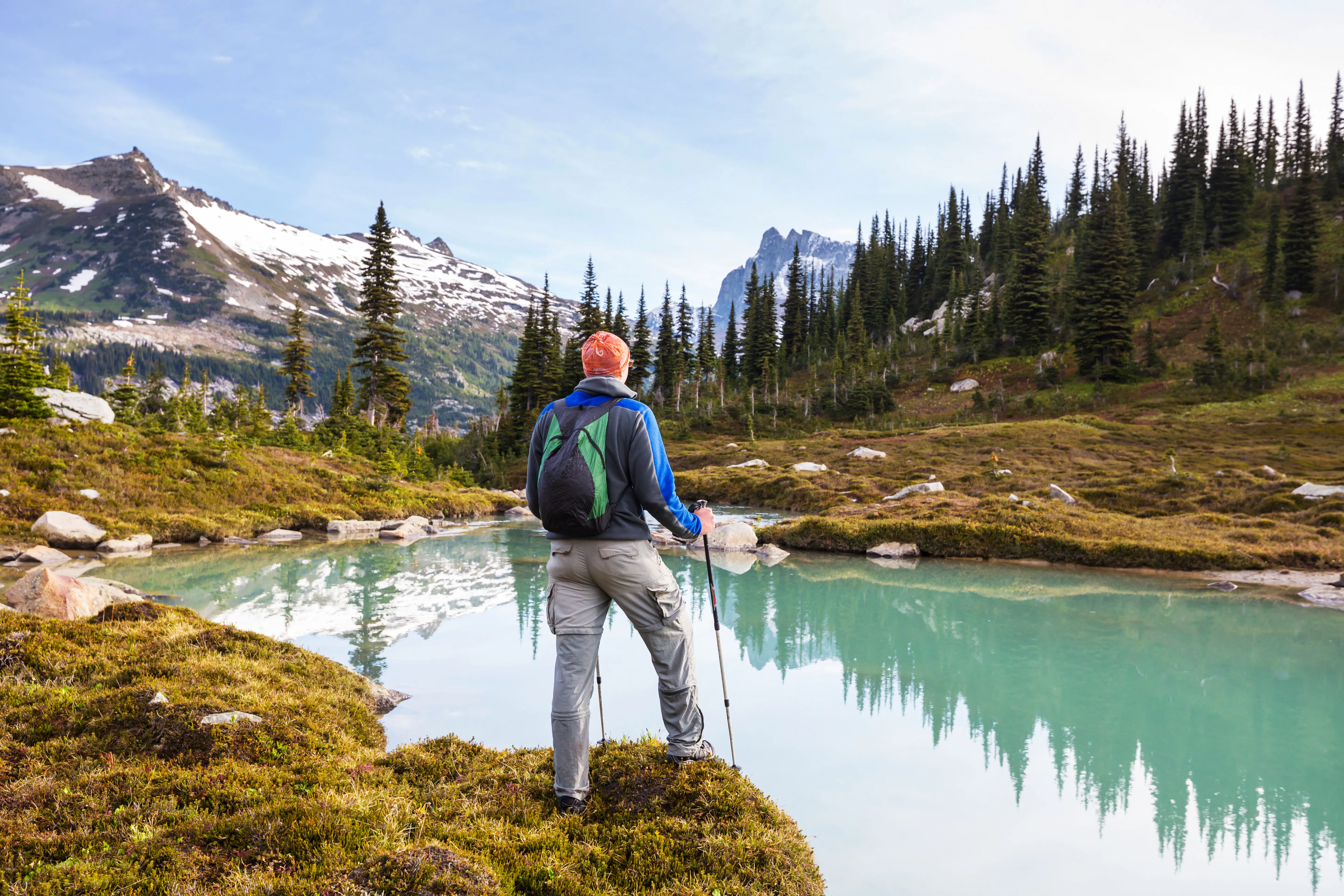 Hiker overlooking a turquoise alpine lake in Garibaldi Provincial Park