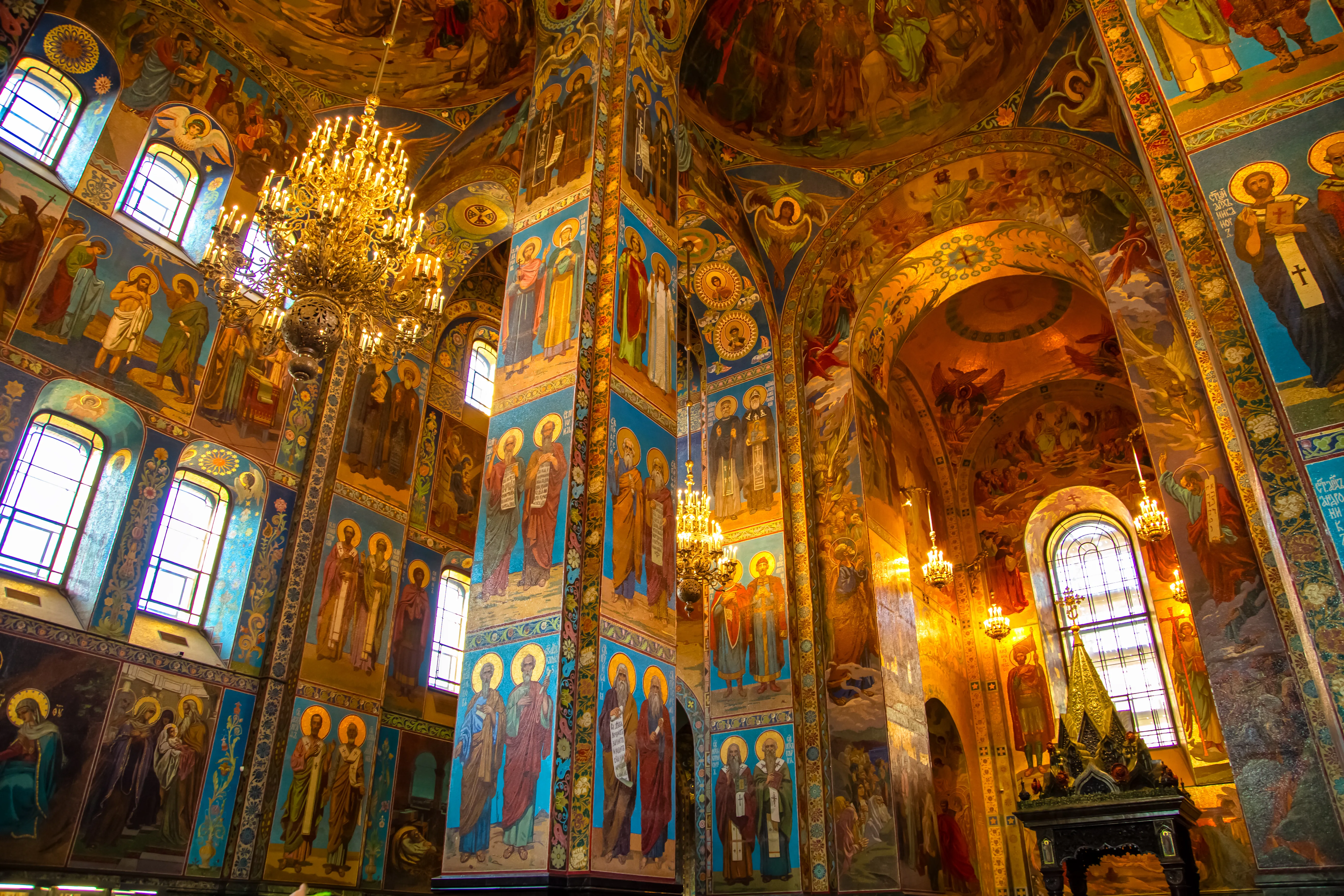 An interior photograph shows the highly detailed mosaic walls and columns inside the Church of the Savior on Blood in Saint Petersburg, Russia.