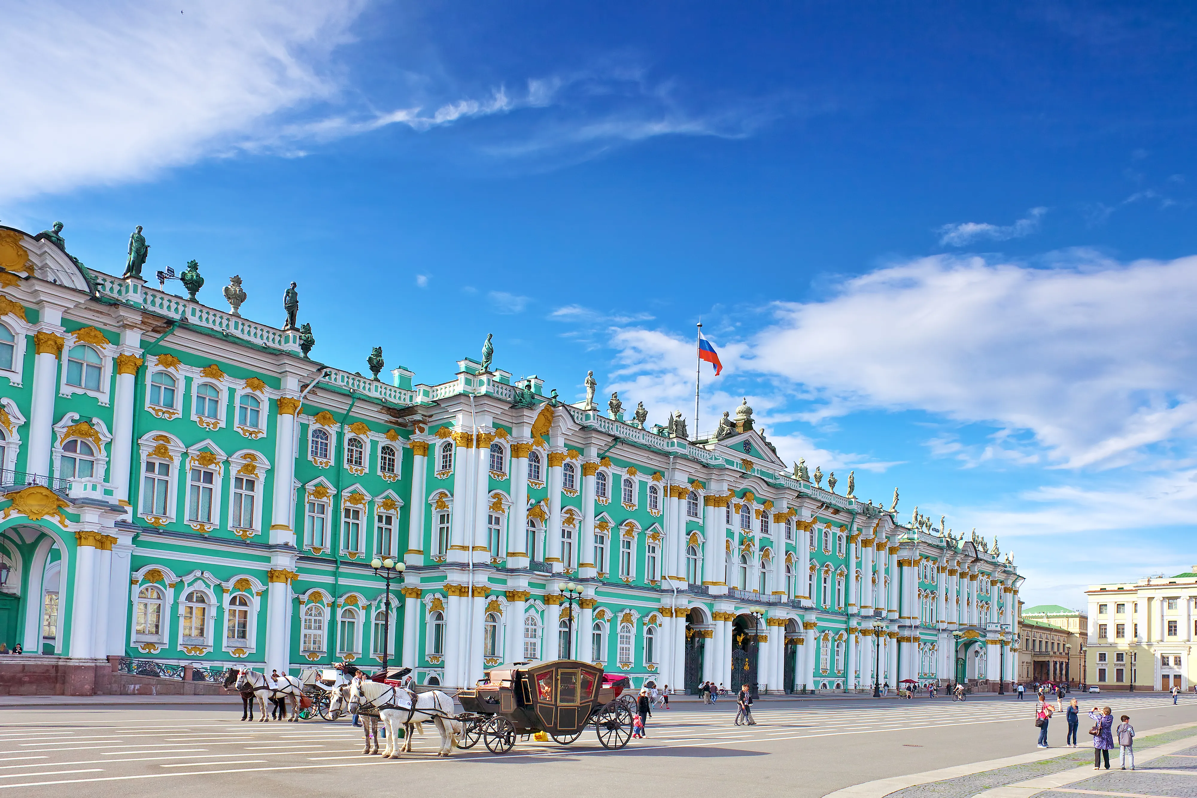 An architectural photograph shows the Winter Palace, part of the State Hermitage Museum, under a blue sky in Palace Square, Saint Petersburg, Russia