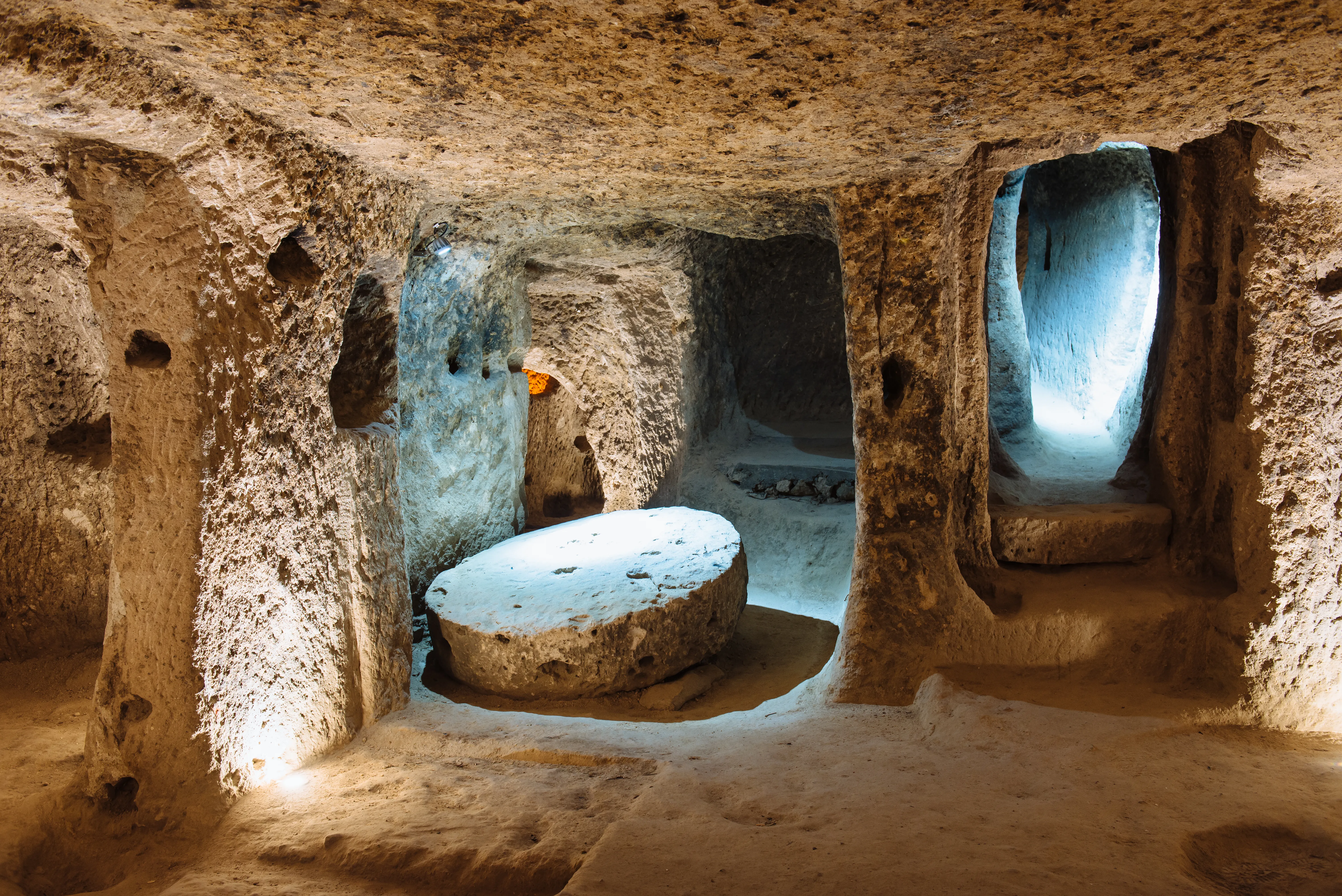 An architectural and historical photograph shows the ancient interior chambers of the Derinkuyu Underground City in Cappadocia, Turkey