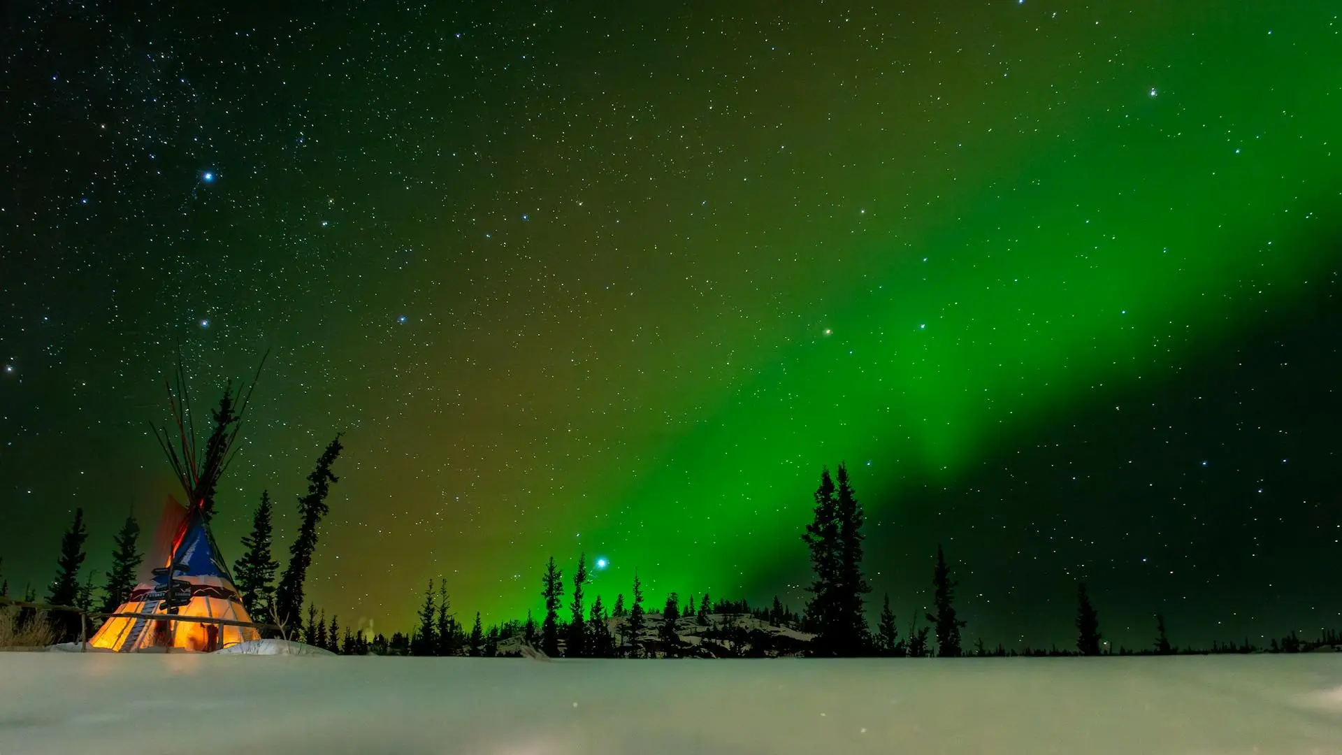 Green Northern Lights shining across a star-filled sky in Yukon